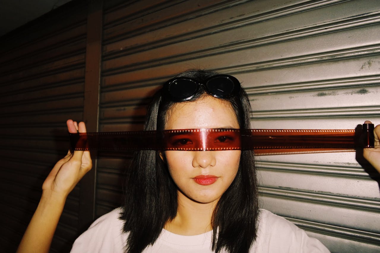 my-steps Creative portrait of a woman using a film strip as sunglasses in an urban environment.